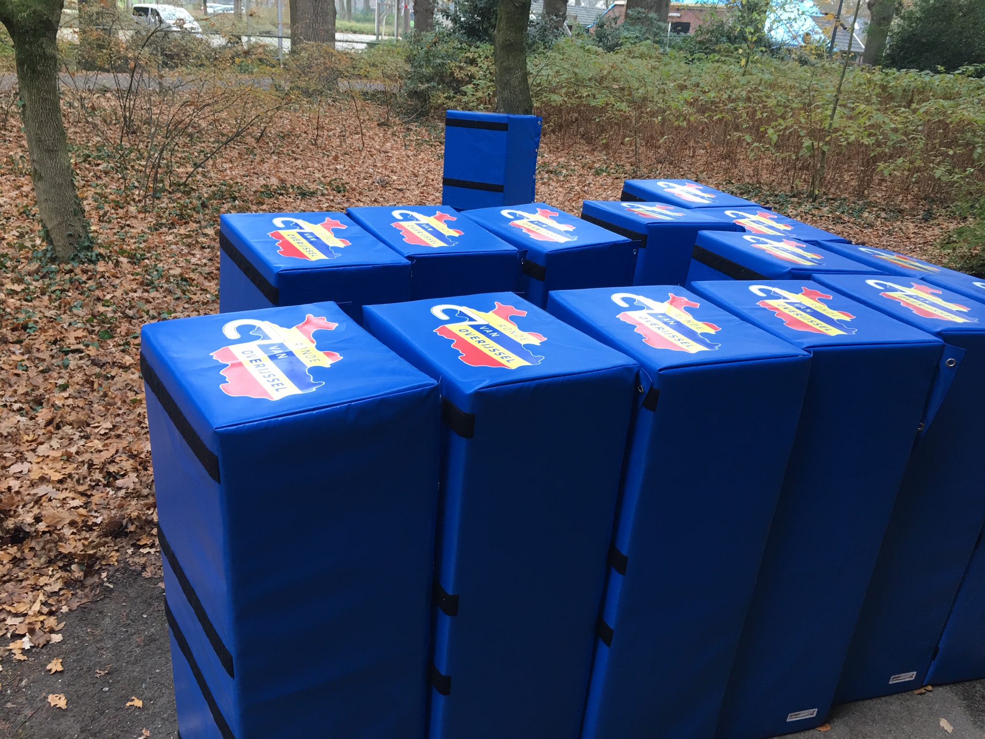 Vierkante beschermhoezen met logo op wielerparcours Ronde van Overijssel